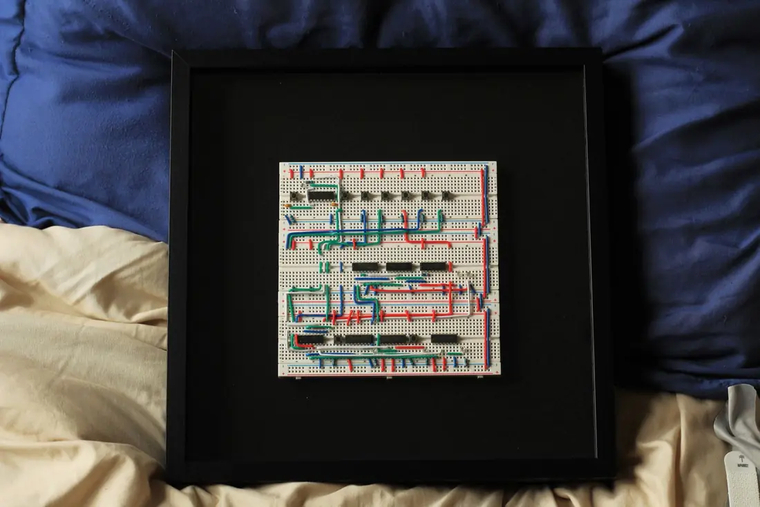 The Logic Frame Display Edition: three breadboards with logic chips and hand-bent wire in a 12 by 12 inch black shadow box