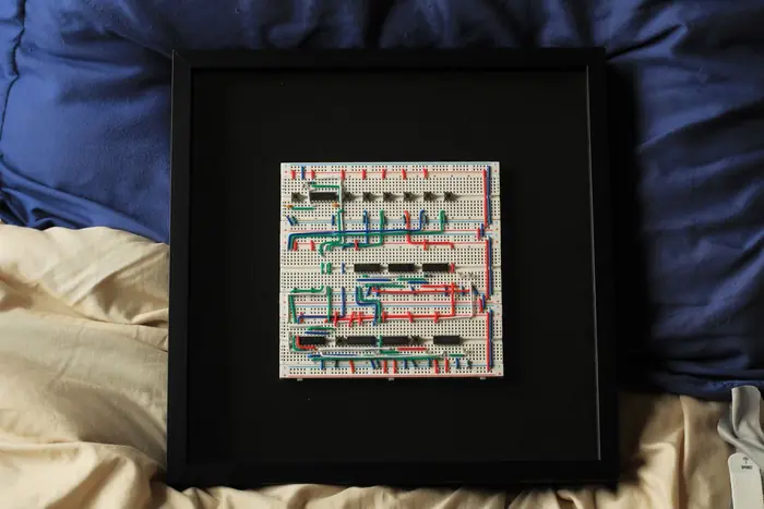 The Logic Frame Display Edition: three breadboards with logic chips and hand-bent wire in a 12 by 12 inch black shadow box