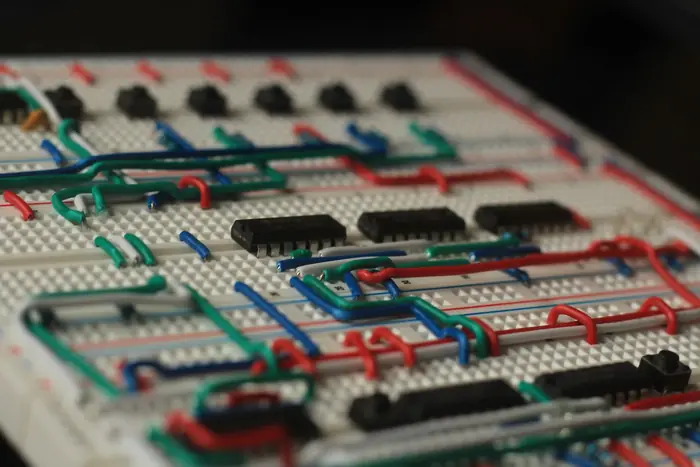 Low-angle close-up of red, blue, green and white wire runs between logic chips